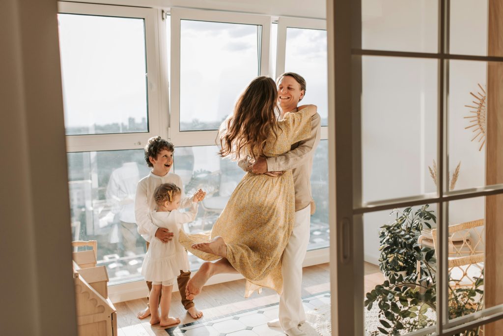 A joyful family embraces in a sunlit modern apartment, celebrating togetherness and love.