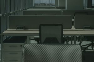 A sleek modern office with multiple desks and chairs, showcasing an empty and orderly workspace.